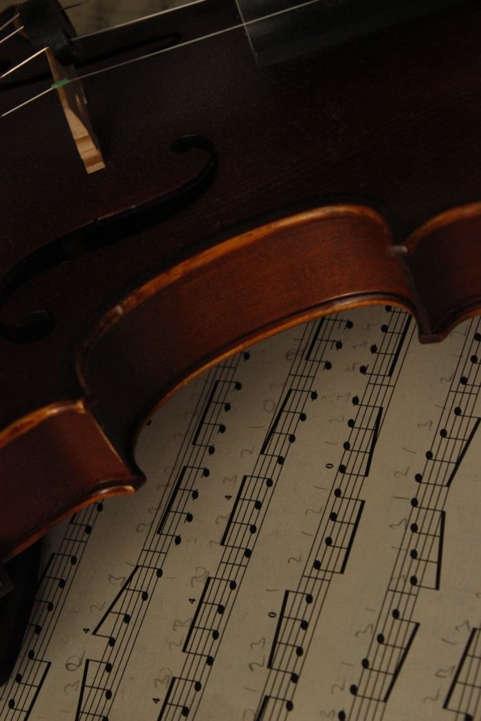 Captivating image of a violin with sheet music, ideal for classical music themes.