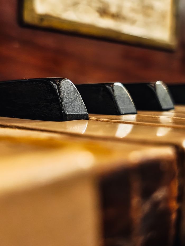 Detailed close-up view of vintage piano keys showcasing texture and warm tones, perfect for music and art themes.